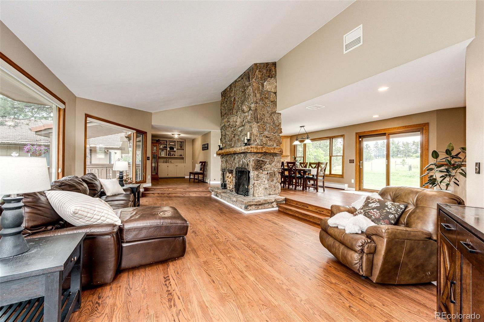 8788 East Tanglewood Road Franktown, CO 80116 - Photo 11 of 48 a living room with fireplace furniture and a large window