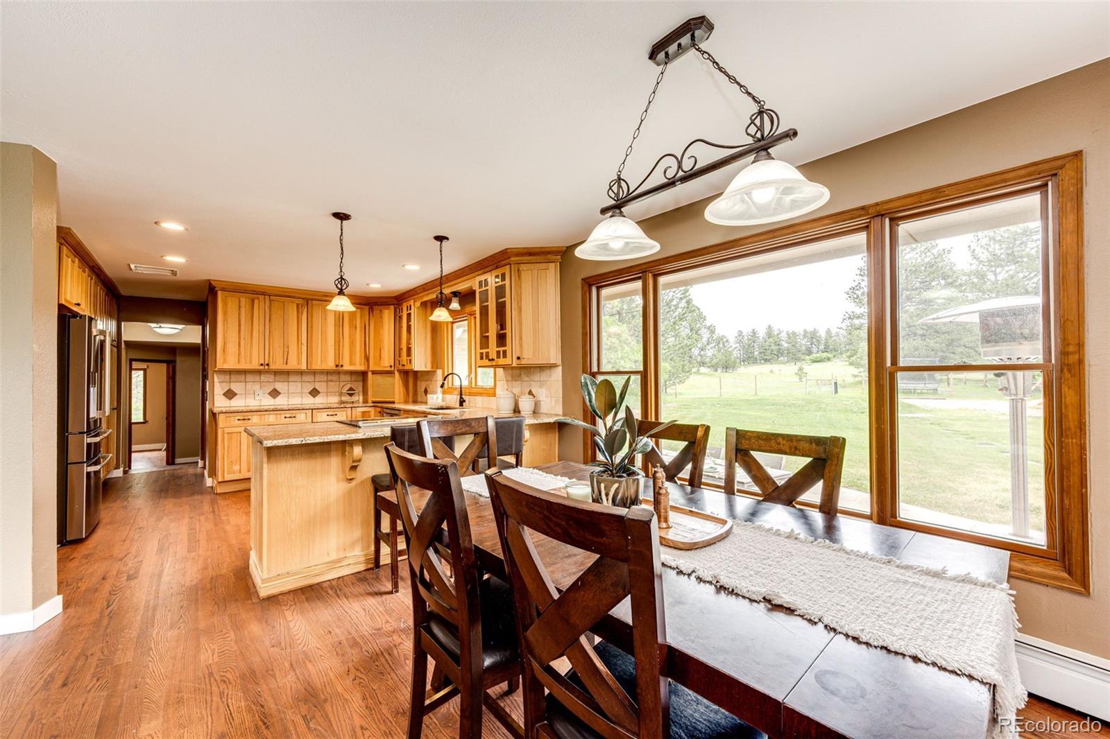 8788 East Tanglewood Road Franktown, CO 80116 - Photo 12 of 48 a view of a dining room with furniture window and wooden floor