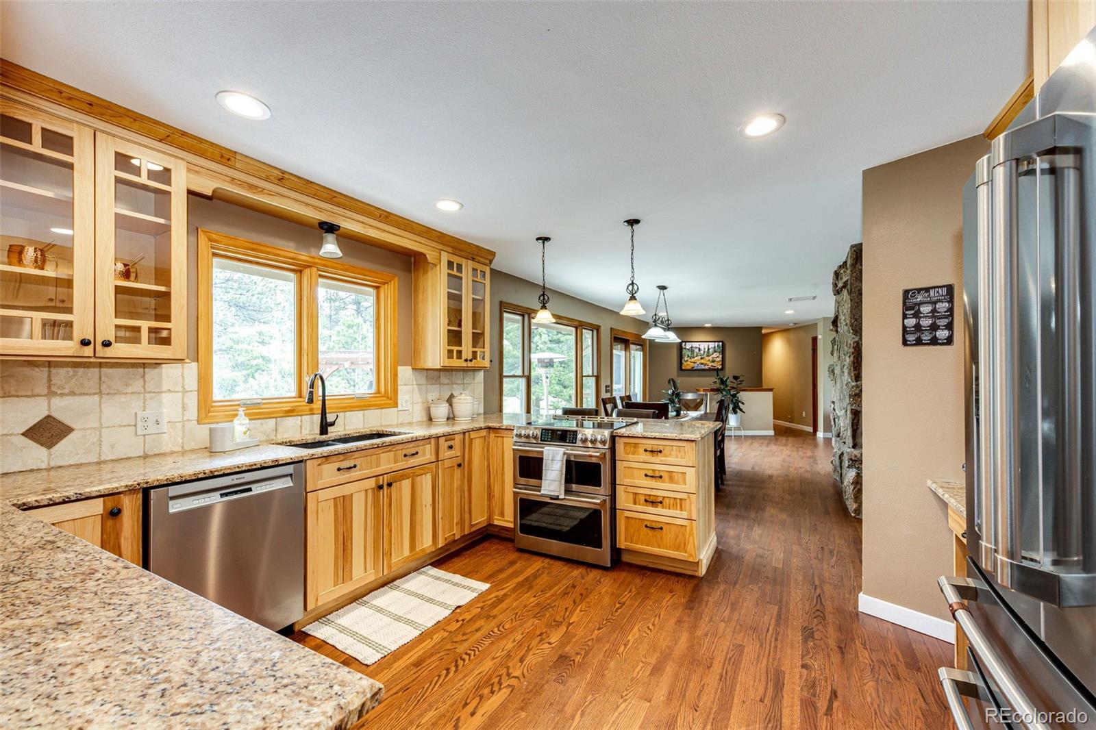 8788 East Tanglewood Road Franktown, CO 80116 - Photo 14 of 48 a kitchen with stainless steel appliances granite countertop a stove and a refrigerator