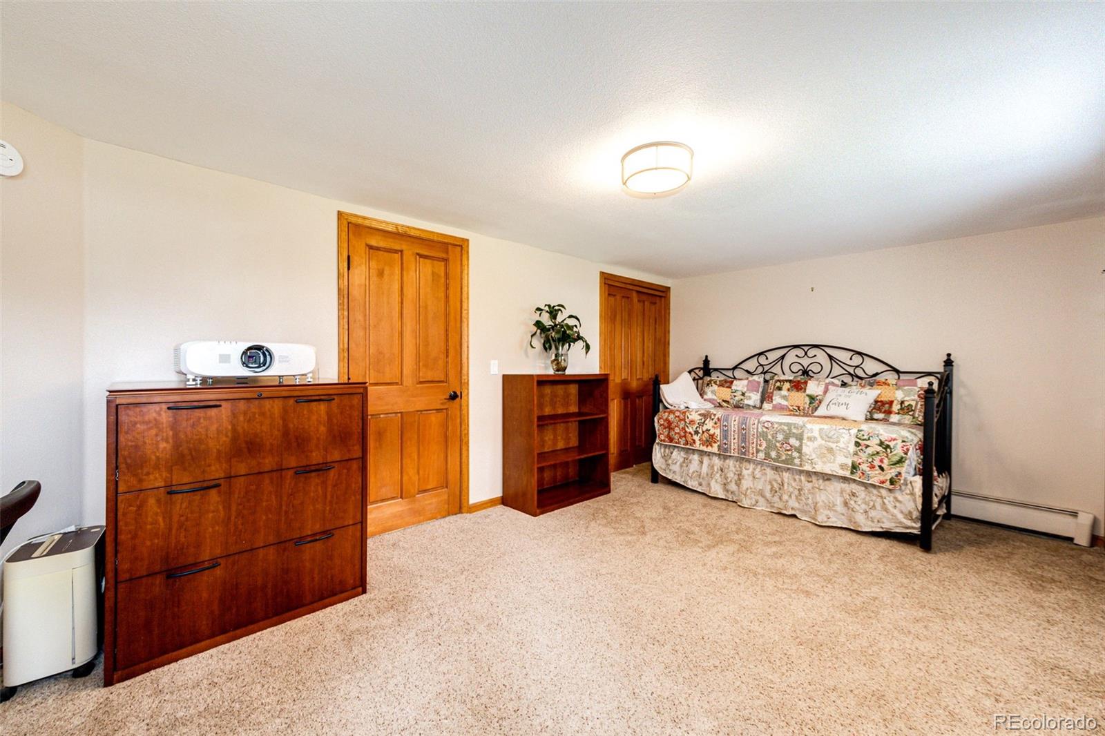 8788 East Tanglewood Road Franktown, CO 80116 - Photo 22 of 48 a bedroom with a bed and a dresser