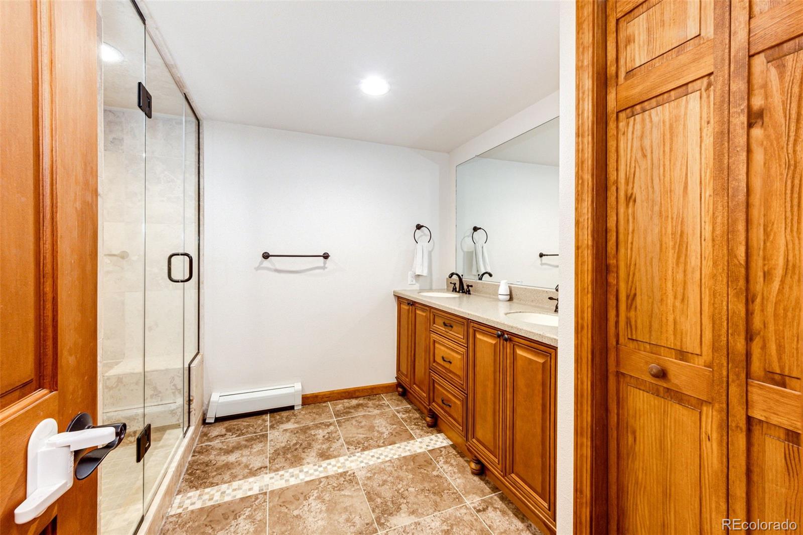 8788 East Tanglewood Road Franktown, CO 80116 - Photo 23 of 48 a bathroom with a double vanity sink and a mirror