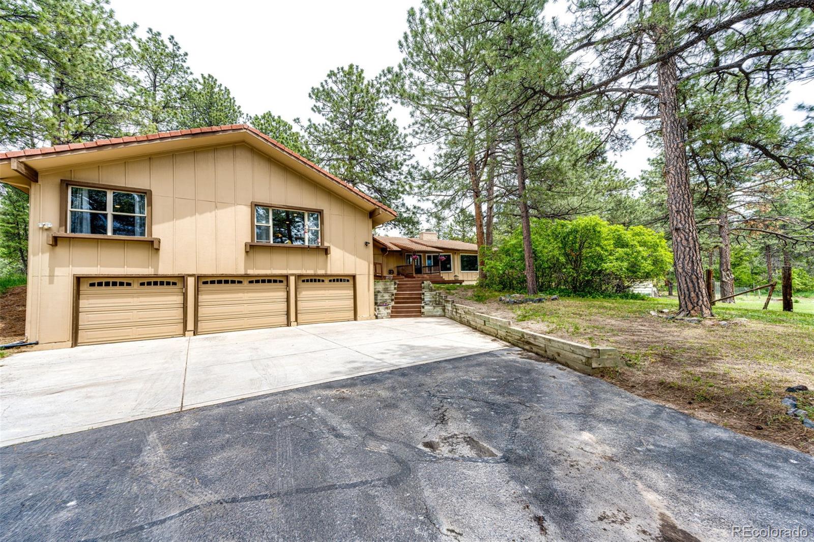 8788 East Tanglewood Road Franktown, CO 80116 - Photo 24 of 48 a view of a house with a yard and large tree