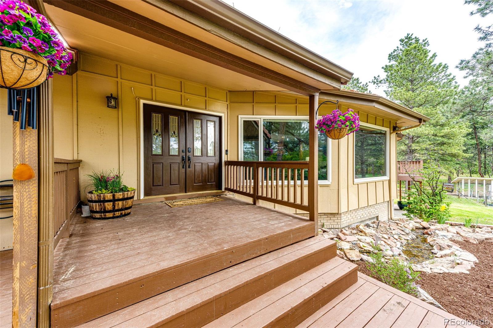 8788 East Tanglewood Road Franktown, CO 80116 - Photo 25 of 48 a view of a house with a porch