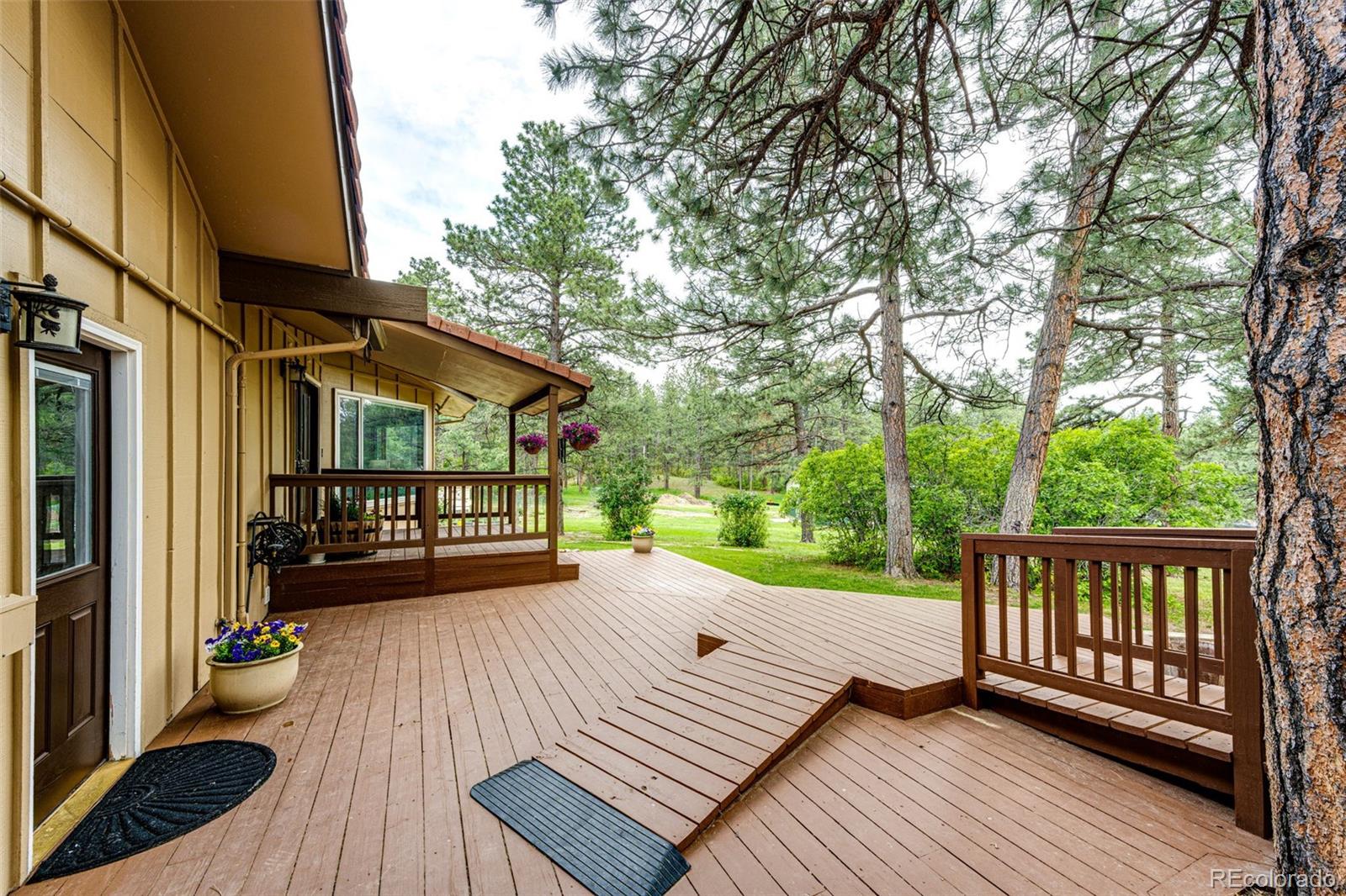 8788 East Tanglewood Road Franktown, CO 80116 - Photo 27 of 48 a view of a wooden deck with a patio