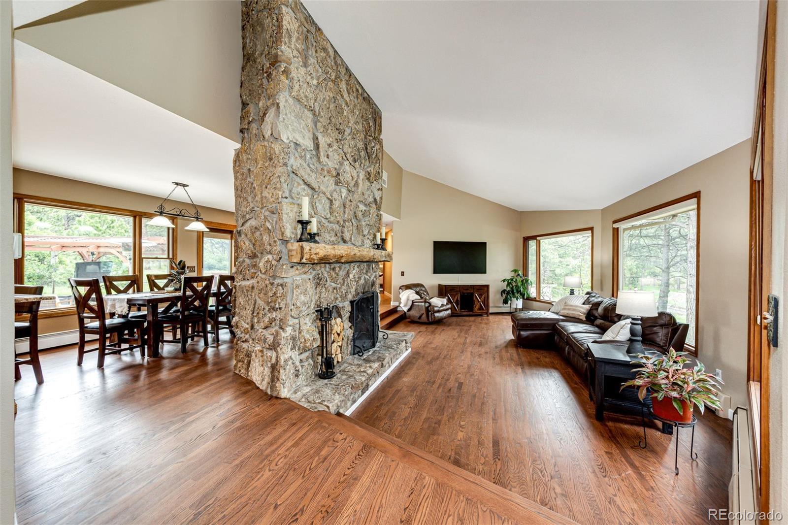 8788 East Tanglewood Road Franktown, CO 80116 - Photo 3 of 48 a living room with fireplace furniture and a wooden floor