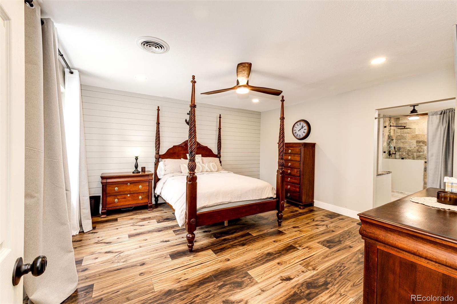 8788 East Tanglewood Road Franktown, CO 80116 - Photo 31 of 48 a bedroom with a bed and wooden floor