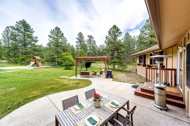 a view of a house with backyard and sitting area