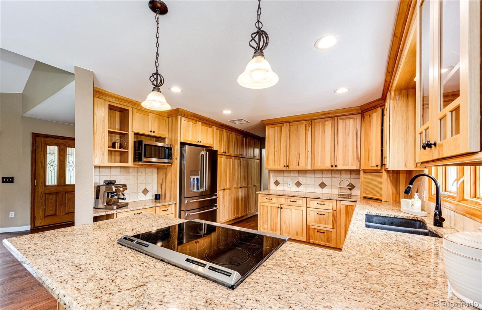 8788 East Tanglewood Road Franktown, CO 80116 - Photo 4 of 48 a kitchen with stainless steel appliances granite countertop a sink stove and refrigerator