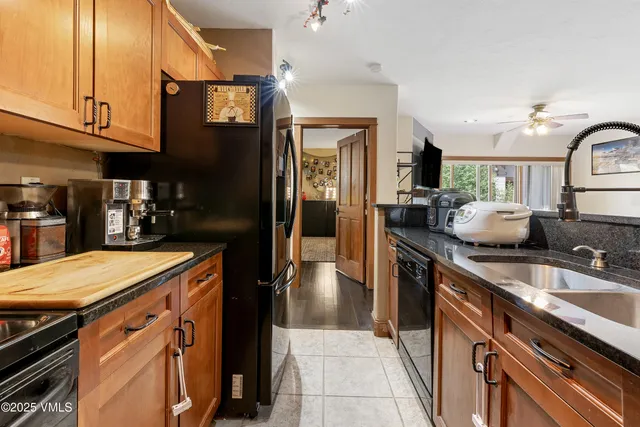 a kitchen with granite countertop a sink stove and refrigerator