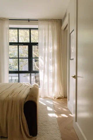 a bedroom with a bed and a large window