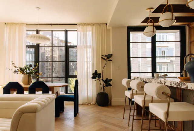 a living room with furniture a table and a large window