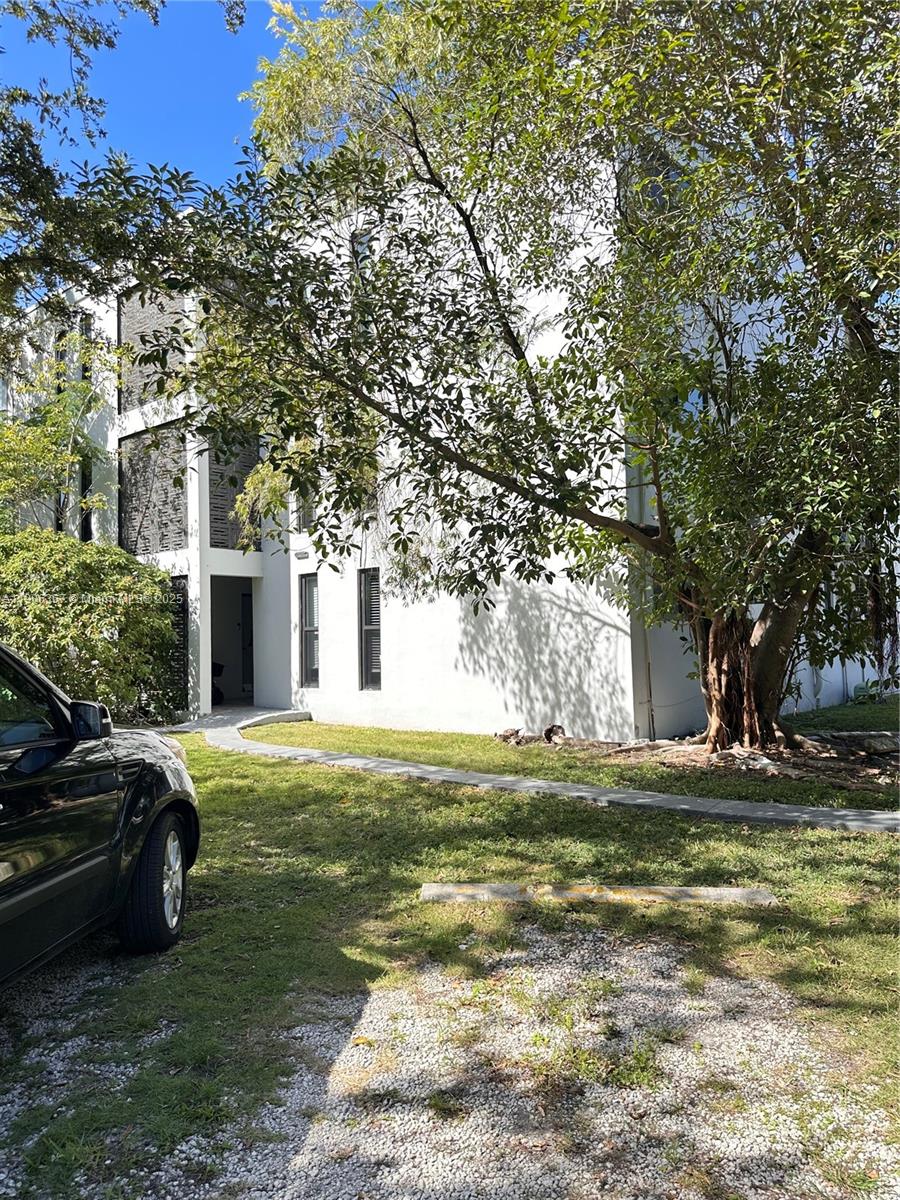 5991 Southwest 76th Street, Unit C4 South Miami, FL 33143 - Photo 1 of 19 a house view with a sitting space and garden