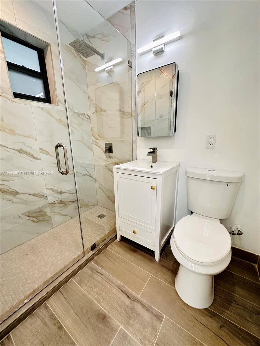5991 Southwest 76th Street, Unit C4 South Miami, FL 33143 - Photo 17 of 19 a bathroom with a toilet sink and mirror