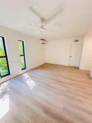 an empty room with windows and closet