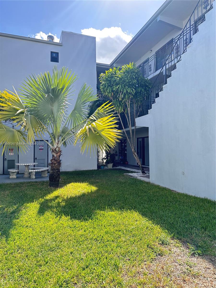 5991 Southwest 76th Street, Unit C4 South Miami, FL 33143 - Photo 2 of 19 a view of a house with a swimming pool and a yard