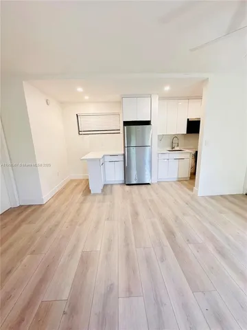 a view of a kitchen with wooden floor and a sink