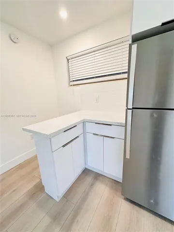 a kitchen with white cabinets and white appliances