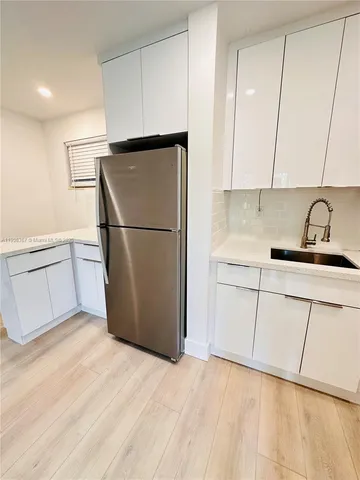a kitchen with a refrigerator sink and cabinets