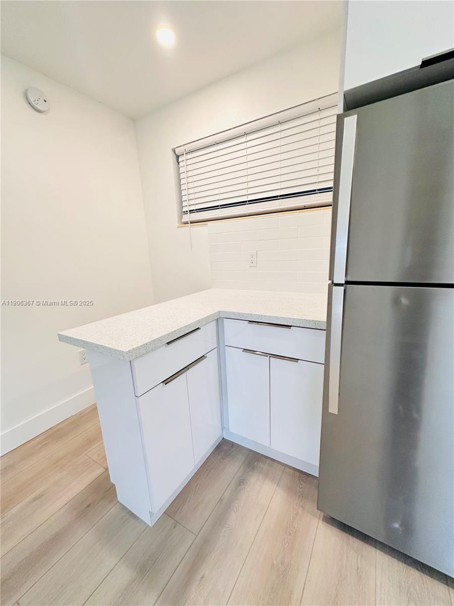 5991 Southwest 76th Street, Unit C4 South Miami, FL 33143 - Photo 8 of 19 a kitchen with white cabinets and white appliances