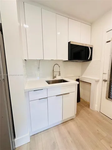 a kitchen with stainless steel appliances granite countertop a sink a stove a microwave and cabinets