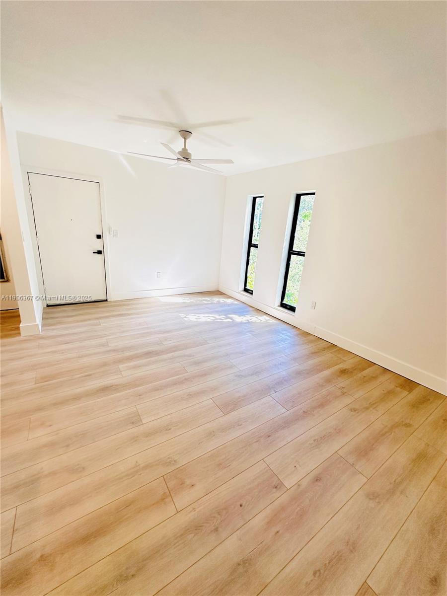 5991 Southwest 76th Street, Unit C4 South Miami, FL 33143 - Photo 10 of 19 an empty room with wooden floor and ceiling fan