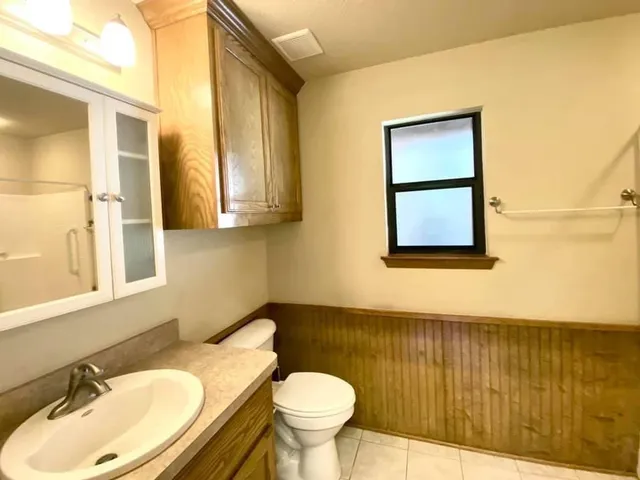 a bathroom with a toilet sink and mirror