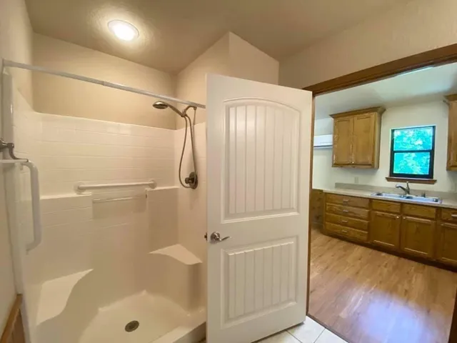 a bathroom with a granite countertop shower mirror and a bathtub