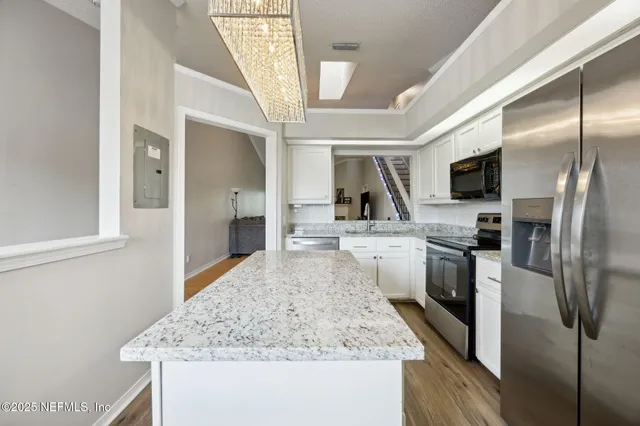 a kitchen with stainless steel appliances granite countertop a sink a stove and a refrigerator