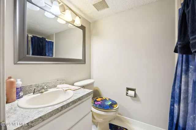 a spacious bathroom with a granite countertop sink and a mirror