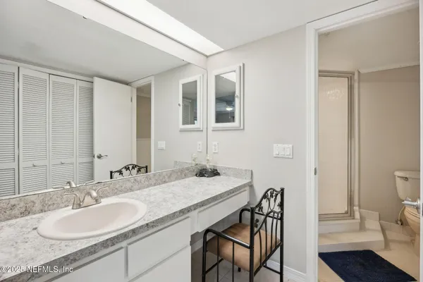 a bathroom with a granite countertop sink a toilet and a mirror