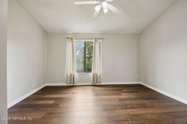 wooden floor in an empty room with a window