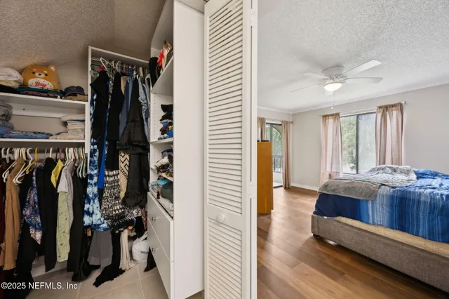 a view of walk in closet with clothes and shoes