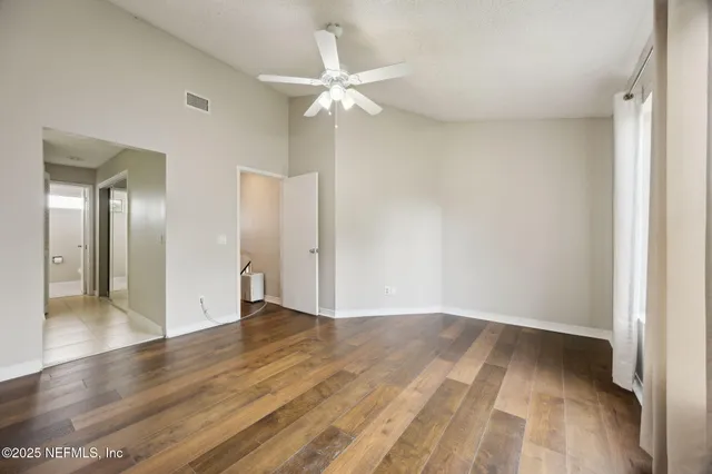 a view of an empty room with wooden floor