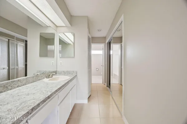 a spacious bathroom with a granite countertop sink and a mirror