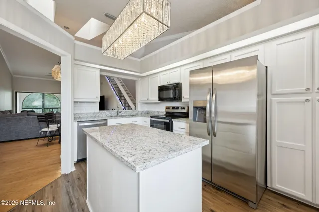 a view of a livingroom with furniture and a kitchen