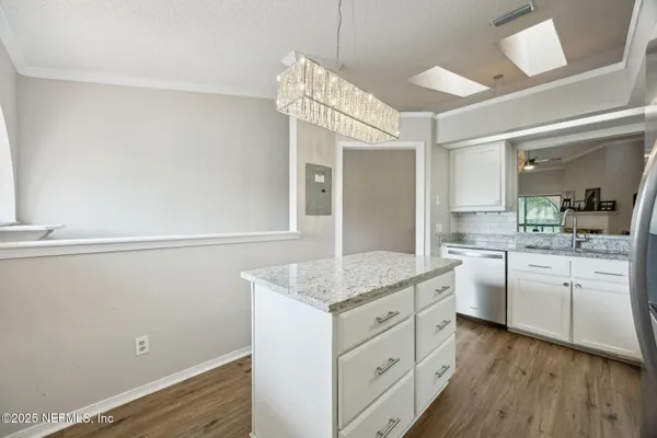 a kitchen with cabinets appliances and a wooden floor