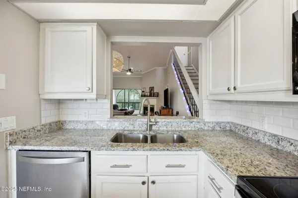 a kitchen with granite countertop a sink and cabinets