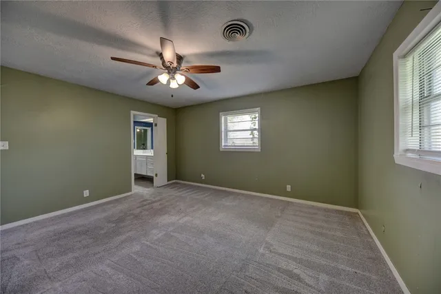 a view of a green field with wooden fence