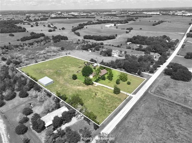 a view of a big yard with a house in the background