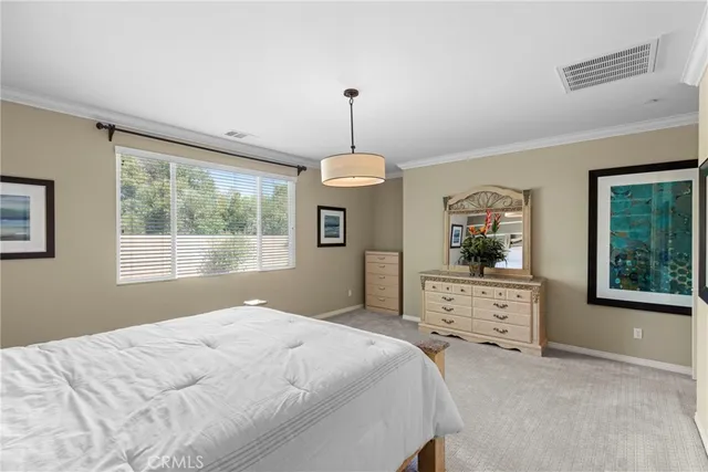 a bedroom with a bed chandelier and window