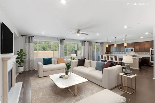 a living room with furniture kitchen view and a large window