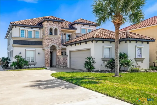 a front view of a house with a yard and palm tree