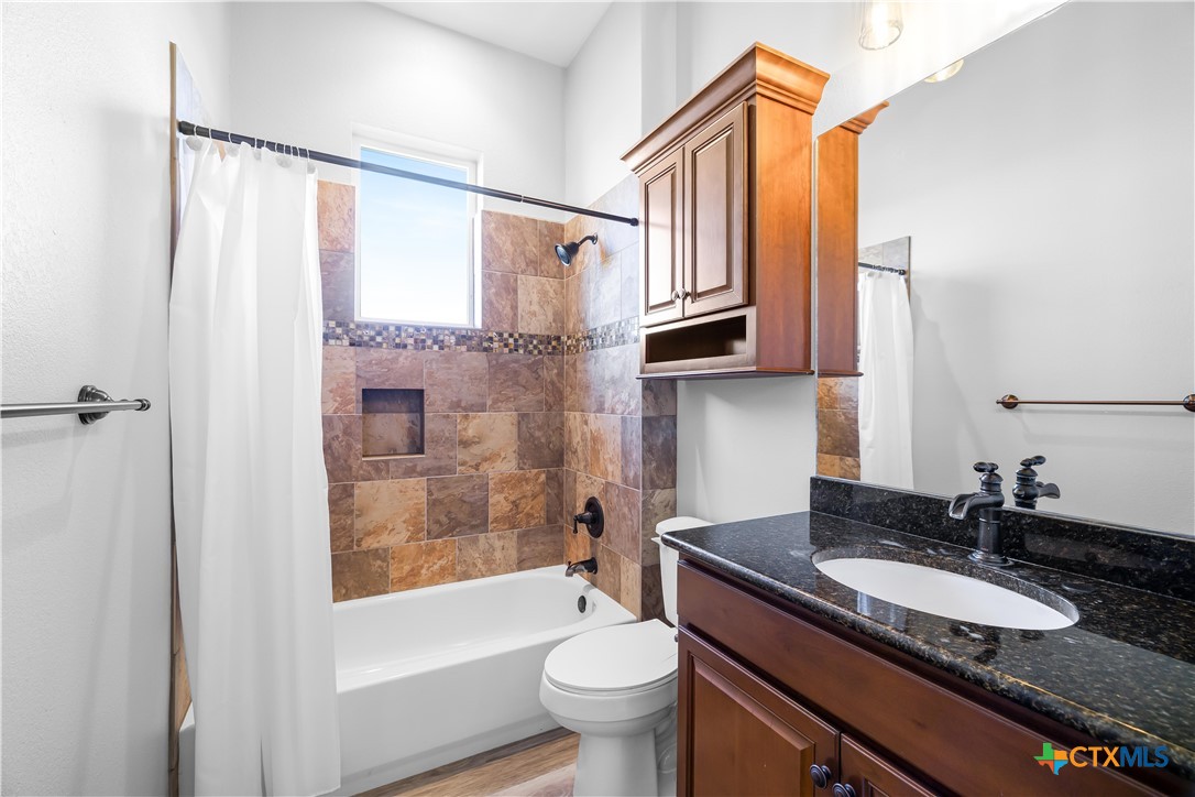 559 West Lago Loop Road Port O'Connor, TX 77982 - Photo 18 of 44 a bathroom with a granite countertop sink toilet and shower