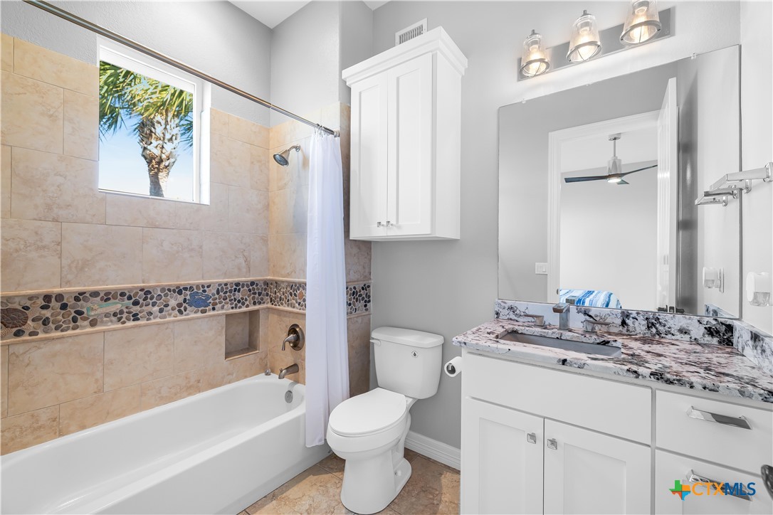 559 West Lago Loop Road Port O'Connor, TX 77982 - Photo 20 of 44 a bathroom with a granite countertop sink toilet and bathtub