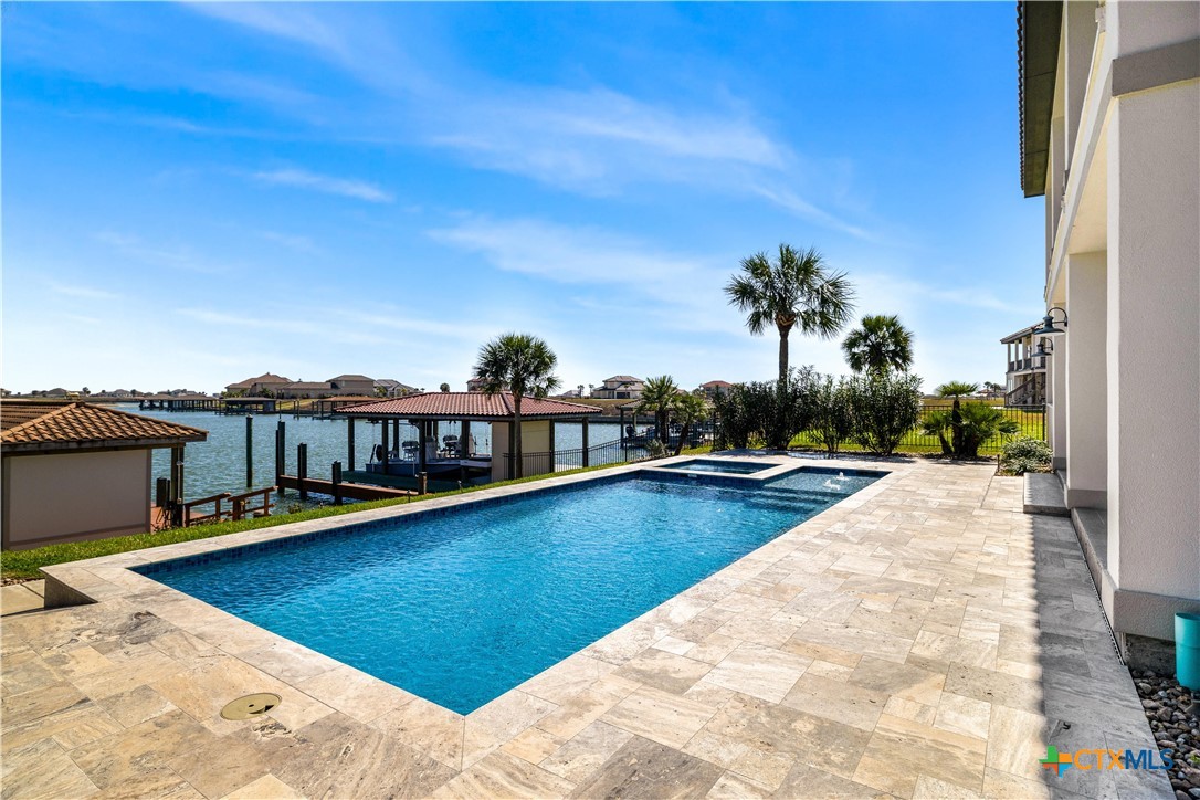 559 West Lago Loop Road Port O'Connor, TX 77982 - Photo 41 of 44 a view of a swimming pool with a lawn chairs under an umbrella