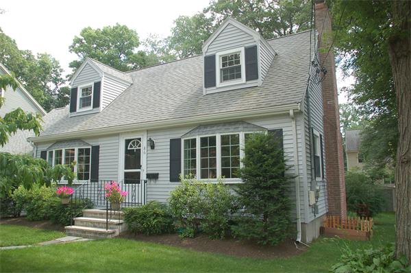 86 Arch Street Needham, MA 02492 - Photo 1 of 24 a view of a house with brick walls and a yard with potted plants