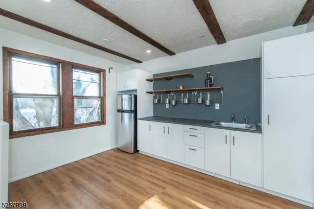 a kitchen with granite countertop white cabinets and white appliances