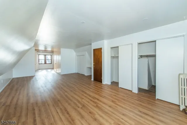 a view of a big room with wooden floor and windows