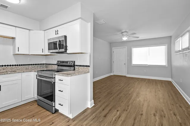 a kitchen with granite countertop a stove a sink and a microwave