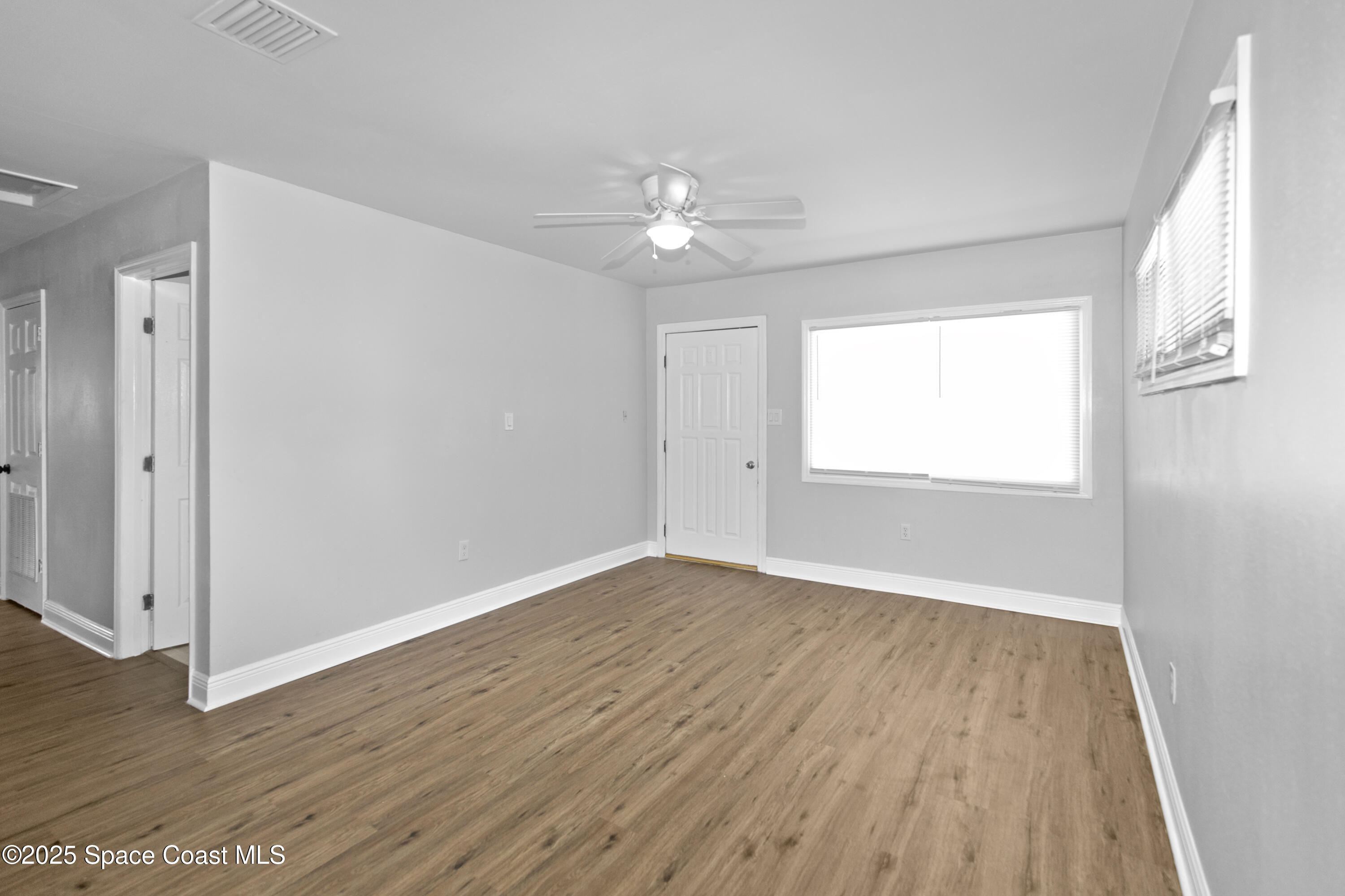 905 North Carpenter Road Titusville, FL 32796 - Photo 12 of 27 a view of an empty room with wooden floor and a window